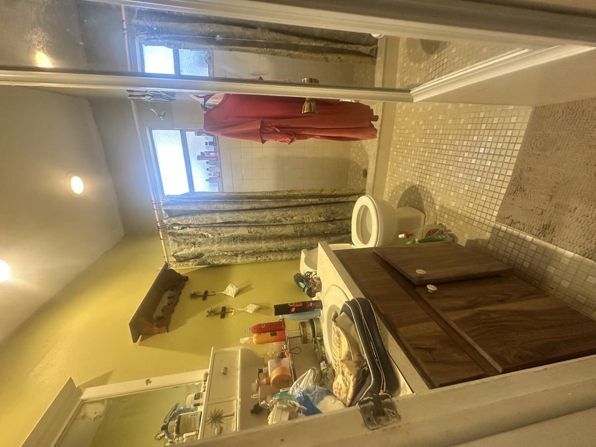 Original dated bathroom with mosaic tile floor and worn fixtures